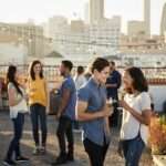 Friends Gathered On Rooftop Terrace For Party With City Skyline In Background